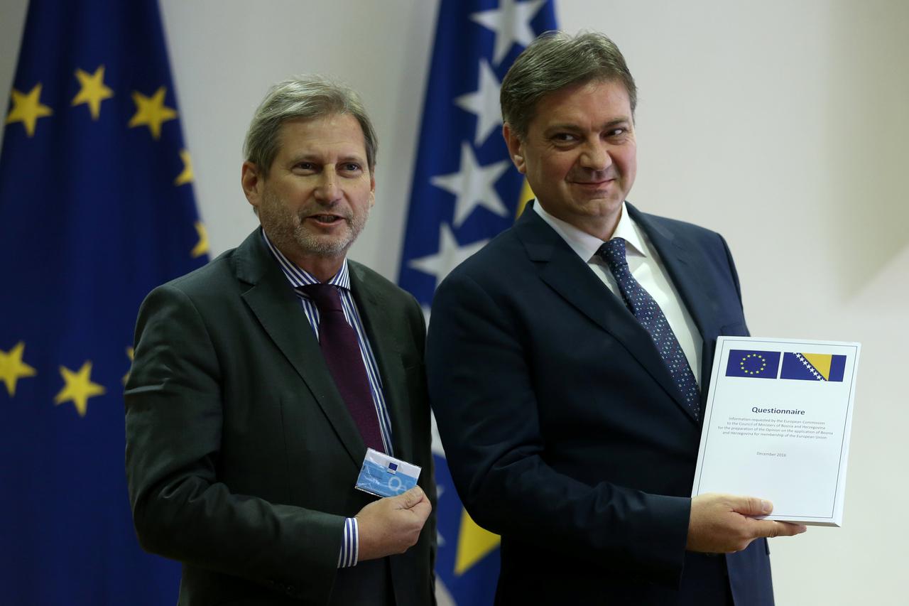 EU enlargement commissioner Johannes Hahn hands the Questionnaire of the European Commission to Bosnian Prime Minister Denis Zvizdic, after the EU approved Bosnia's application to join the bloc in September, in Sarajevo European Union (EU) enlargement com