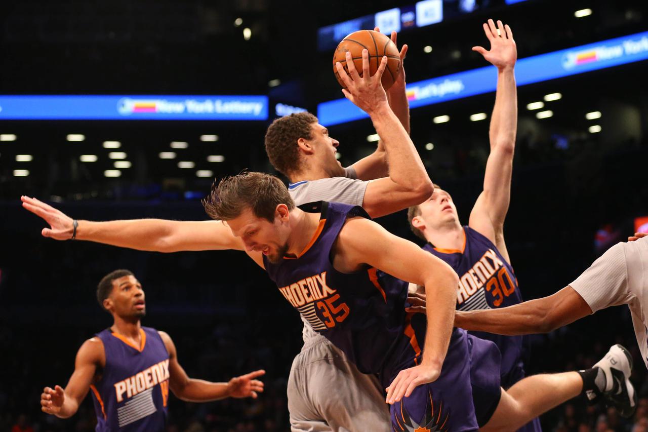 Dec 1, 2015; Brooklyn, NY, USA;  Brooklyn Nets center Brook Lopez (11) moves up between Phoenix Suns forward Mirza Teletovic (35) and forward Jon Leuer (30) during the fourth quarter at Barclays Center. Brooklyn Nets won 94-91. Mandatory Credit: Anthony G